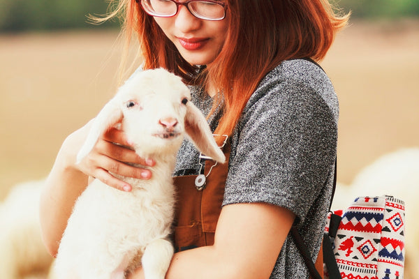 woman carrying a goat