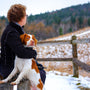person holding tan and white dog sitting on bench