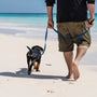 man in black t-shirt and brown shorts standing on beach with black and tan short