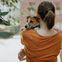 woman in orange shirt holding green plant