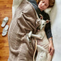 white short coated small sized dog on woman in gray sweater
