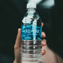 person holding clear plastic bottle