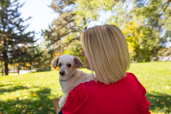 a woman in a red shirt holding a white dog