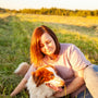 a person sitting in a field with a dog