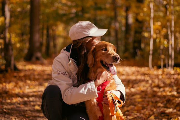 a woman kneeling down with a dog in her lap