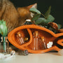a cat sniffing a vase with small bottles in it