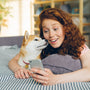 a woman laying on top of a bed next to a dog