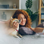 a woman laying on a bed holding a dog
