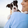 Woman happily holds a cute puppy.