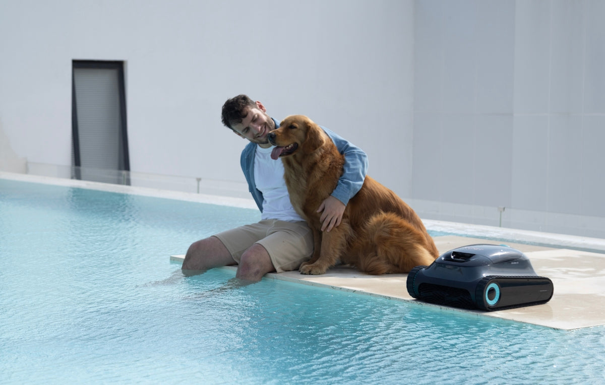 Man and dog relax by the pool with robot.