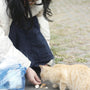 Woman feeds a cat some food outside.