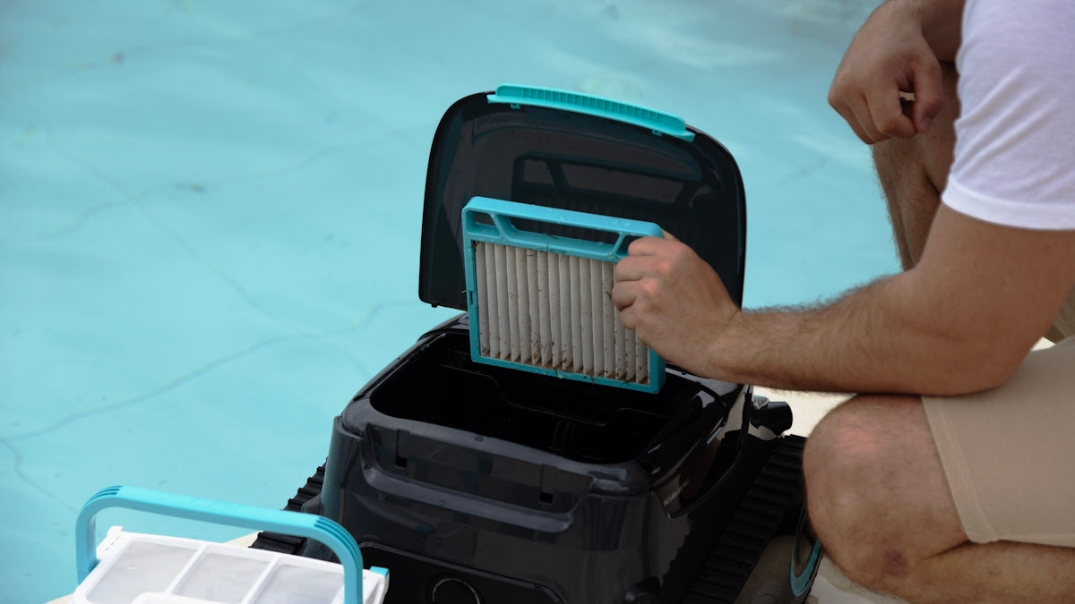 Someone is cleaning the filter of a pool cleaner.