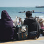 People relax at the beach with their dog.