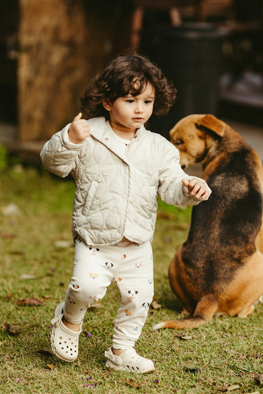 A child plays while a dog watches nearby.