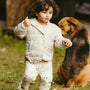 A child plays while a dog watches nearby.