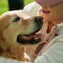 Woman lovingly pets her happy golden retriever.
