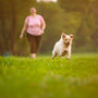 woman in pink shirt and pink shorts running on green grass field during daytime