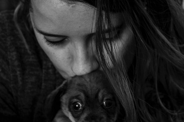 grayscale photo of woman carrying dog