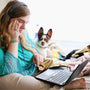 woman in teal long sleeve shirt holding black laptop computer