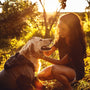 woman in black shirt hugging golden retriever