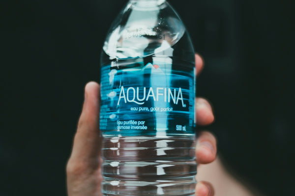 person holding clear plastic bottle