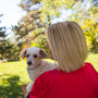 a woman in a red shirt holding a white dog
