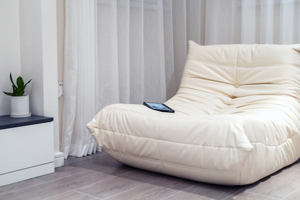 a white bed with a white curtain