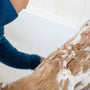 a person washing a dog in a bath tub