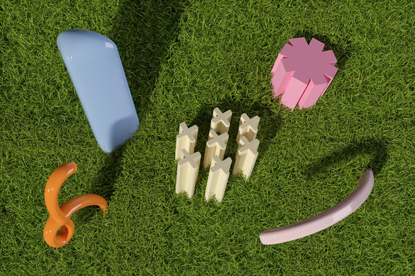 a group of toys laying on top of a lush green field