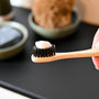 a person holding a toothbrush with a toothpaste on it
