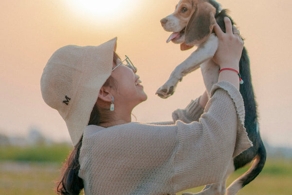 a woman holding a small dog up to her face