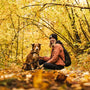 a woman sitting on the ground with her dog