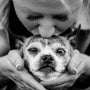 a woman holding a dog in her hands