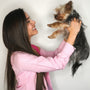 a woman holding a small dog up to her face