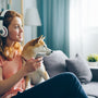 a woman sitting on a couch with a dog wearing headphones