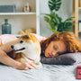 a woman laying on a bed with a dog