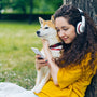 a woman with headphones is holding a dog