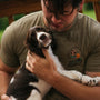 A man sitting on a bench holding a dog