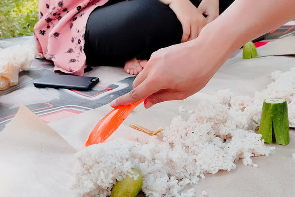 A woman is cutting carrots on a table