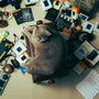 A cat laying on top of a chair covered in toys