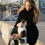 A woman is petting a cat on the street