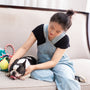 Woman pets a boston terrier on a sofa.