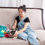 Woman cuddles with a dog on a couch.