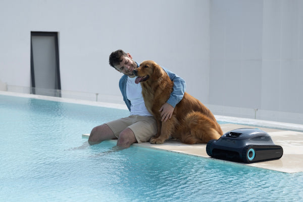 Man and dog relax by the pool with robot.