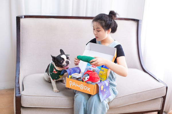 A woman and dog unpack a pawbox.