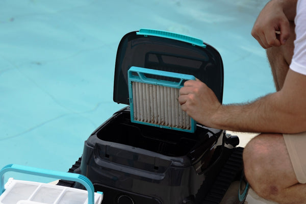 Someone is cleaning the filter of a pool cleaner.