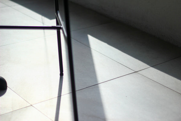 Shadows and light illuminate a tiled floor.