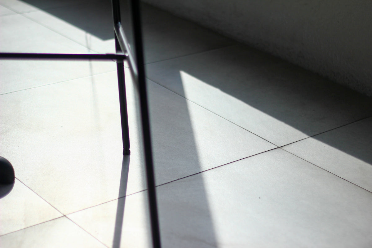 Shadows and light illuminate a tiled floor.