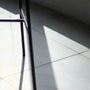 Shadows and light illuminate a tiled floor.