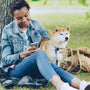 Woman and dog relax under a tree together.